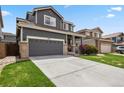 Attractive two-story home featuring a well-manicured lawn, gray exterior, and an attached two-car garage at 16164 E Hinsdale Ave, Aurora, CO 80016