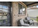Cozy front porch with seating, brick accents, and a secure front door at 16164 E Hinsdale Ave, Aurora, CO 80016
