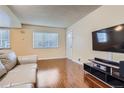 Bright living room featuring wood floors, a comfortable sofa, and a large window with natural light at 13343 E Louisiana Ave, Aurora, CO 80012
