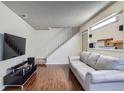 Cozy living room with hardwood floors, a comfortable sofa, and access to the staircase at 13343 E Louisiana Ave, Aurora, CO 80012