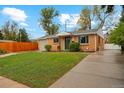 Inviting brick house featuring a green lawn and a concrete driveway at 5930 W 34Th Ave, Wheat Ridge, CO 80212