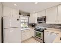Kitchen with stainless steel appliances, white cabinets, and a tiled backsplash at 2890 W Long Cir # A, Littleton, CO 80120