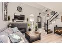 Cozy living room featuring a fireplace, hardwood floors, and a staircase at 2890 W Long Cir # A, Littleton, CO 80120