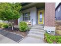 Inviting front entrance with a bright yellow door, well-maintained landscaping, and modern architectural details at 6682 Osage St, Denver, CO 80221