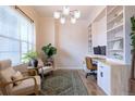 Comfortable home office featuring built-in shelving, neutral decor, and ample natural light at 6682 Osage St, Denver, CO 80221