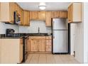 Well-lit kitchen features wood cabinets, granite countertops, and stainless-steel appliances at 969 S Pearl St # 103, Denver, CO 80209