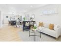 Open-concept living room with modern decor, light wood floors, and an adjacent dining area at 3150 S Pennsylvania Street, Englewood, CO 80113