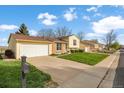 Suburban homes along a street show tidy lawns, driveways, and garages on a sunny day with blue skies at 814 Glenwood Dr, Lafayette, CO 80026
