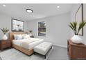 This is a bedroom with a bed, nightstands, and a large window at 6485 S Havana St # A, Englewood, CO 80111