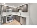 Modern kitchen with stainless steel appliances, stylish cabinets, and quartz countertops at 6485 S Havana St # A, Englewood, CO 80111