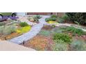 Beautifully landscaped front yard with a stone pathway and vibrant plants at 10902 Bannock St, Northglenn, CO 80234