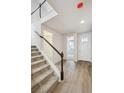 Two-story entryway with staircase, light wood floors, and white trim at 819 Goodrich Peak St, Erie, CO 80516