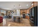 A well-lit kitchen with wood cabinets, stainless steel appliances, and seating at the island at 14921 W 70Th Ave, Arvada, CO 80007