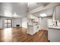 Open living space combining kitchen and living room, featuring a fireplace, balcony, and modern fixtures at 8335 Fairmount Dr # 9-206, Denver, CO 80247