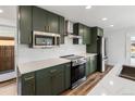 Modern kitchen featuring stylish green cabinets, stainless steel appliances, and quartz countertops at 127 Emerald St, Broomfield, CO 80020