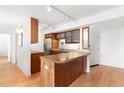 Galley kitchen boasts wooden cabinetry, stainless steel refrigerator and a breakfast bar at 1313 N Williams St # 1003, Denver, CO 80218