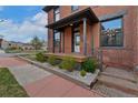 Side angle of porch, featuring stone landscaping, wooden stairs, and stylish railings at 2560 Champa St, Denver, CO 80205