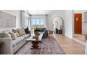 Bright living room boasts large windows, a cozy couch, and stylish decor creating an inviting atmosphere at 6275 Ponderosa Way, Parker, CO 80134