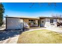 Attractive brick home with a covered porch, inviting outdoor seating, and a well-kept lawn at 3455 Teller St, Wheat Ridge, CO 80033