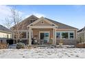 Covered patio with seating area, overlooking a snow-covered yard at 8171 S Catawba Ct, Aurora, CO 80016