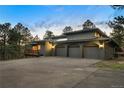 Spacious three-car garage with a large driveway, complemented by solar panels on the roof at 28890 Pinewood Vista Dr, Evergreen, CO 80439
