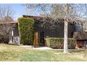 Home exterior featuring manicured hedges and modern wood door and frame at 5200 W Ottawa Ave, Littleton, CO 80128