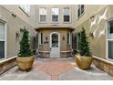 Inviting condo entrance with elegant potted trees and an arched doorway at 40 Madison St # 203, Denver, CO 80206