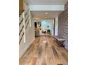 Inviting entryway with wood floors, brick accent wall, stairs, and open view to living area at 8503 E Jamison Ave, Centennial, CO 80112