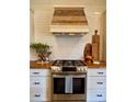 Close-up of stainless steel stove with wood countertops and accents, and subway tile backsplash at 8503 E Jamison Ave, Centennial, CO 80112