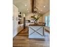 Bright kitchen with white cabinets, wood island countertop, and modern pendant lighting at 8503 E Jamison Ave, Centennial, CO 80112