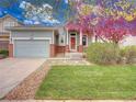 Charming home featuring a well-kept front yard and covered porch with brick columns and a two-car garage at 12948 E 106Th Way, Commerce City, CO 80022