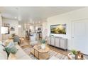 Bright and inviting living room showcasing an open floor plan into the kitchen, perfect for modern living at 22315 E 6Th Ave, Aurora, CO 80018
