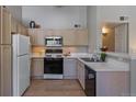 Bright kitchen with white cabinets, stainless steel appliances, and a breakfast bar at 9911 E Idaho Cir # 202, Denver, CO 80247