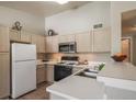 Well-lit kitchen with stainless steel appliances, ample counter space, and neutral cabinetry at 9911 E Idaho Cir # 202, Denver, CO 80247