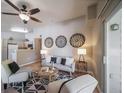 Cozy living room featuring hardwood floors, a ceiling fan, and an open connection to the kitchen at 9911 E Idaho Cir # 202, Denver, CO 80247