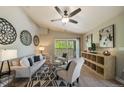 Well-decorated living room with hardwood floors, ceiling fan, and balcony access at 9911 E Idaho Cir # 202, Denver, CO 80247