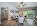 Bright living room with hardwood floors, a ceiling fan, and a sliding glass door to the balcony at 9911 E Idaho Cir # 202, Denver, CO 80247