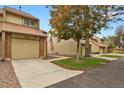 Charming two-story townhome features attached garage, sidewalk, and mature landscaping at 15323 E Louisiana Ave, Aurora, CO 80017
