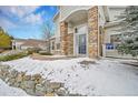 Inviting entrance featuring stone pillars, arched entryway, and a well-maintained walkway with stone retaining wall at 8300 Fairmount Dr # Ff104, Denver, CO 80247