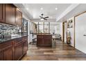 Open kitchen featuring an island with seating, wood floors, and modern fixtures at 4620 Blackhawk Way, Denver, CO 80239