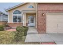 Close up view of home entrance with a white door and brick accents at 5300 Morning Glory Pl, Highlands Ranch, CO 80130