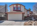 Charming two-story home boasts an attached garage, red trim, and well-manicured landscaping at 19962 E Kent Dr, Aurora, CO 80013