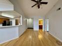 Open living area with hardwood floors, bright lighting, and entry to hall and bathroom at 7440 S Blackhawk St # 208, Englewood, CO 80112