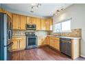 Well-lit kitchen features stainless steel appliances and ample counter space with wood cabinets at 2446 S Gibralter Way, Aurora, CO 80013