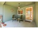 Inviting covered front porch with charming Adirondack chairs, lantern, and a decorative wood and glass front door at 8468 Chase Dr, Arvada, CO 80003