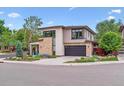 Modern home with a dark gray garage door and stone and tan siding at 4274 E Dickenson Pl, Denver, CO 80222