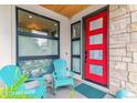 Inviting front porch with a vibrant red door and blue Adirondack chairs at 4274 E Dickenson Pl, Denver, CO 80222