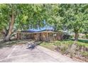 Wide view of charming brick house with mature trees and spacious front yard at 5563 Newland Way, Arvada, CO 80002