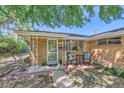 Charming brick home featuring a covered front porch with a cozy seating area at 5563 Newland Way, Arvada, CO 80002