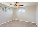 A simple bedroom with carpet, two windows allowing natural light, and ceiling fan at 1121 Rogers St, Golden, CO 80401